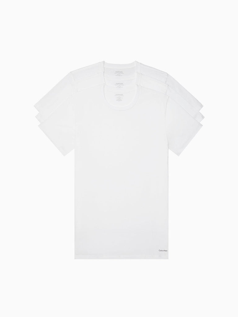 Three plain white cotton classic crewneck tees from Calvin Klein (model NB4051) are stacked in a slightly fanned arrangement, with the front t-shirt fully visible and the others partially shown behind it.