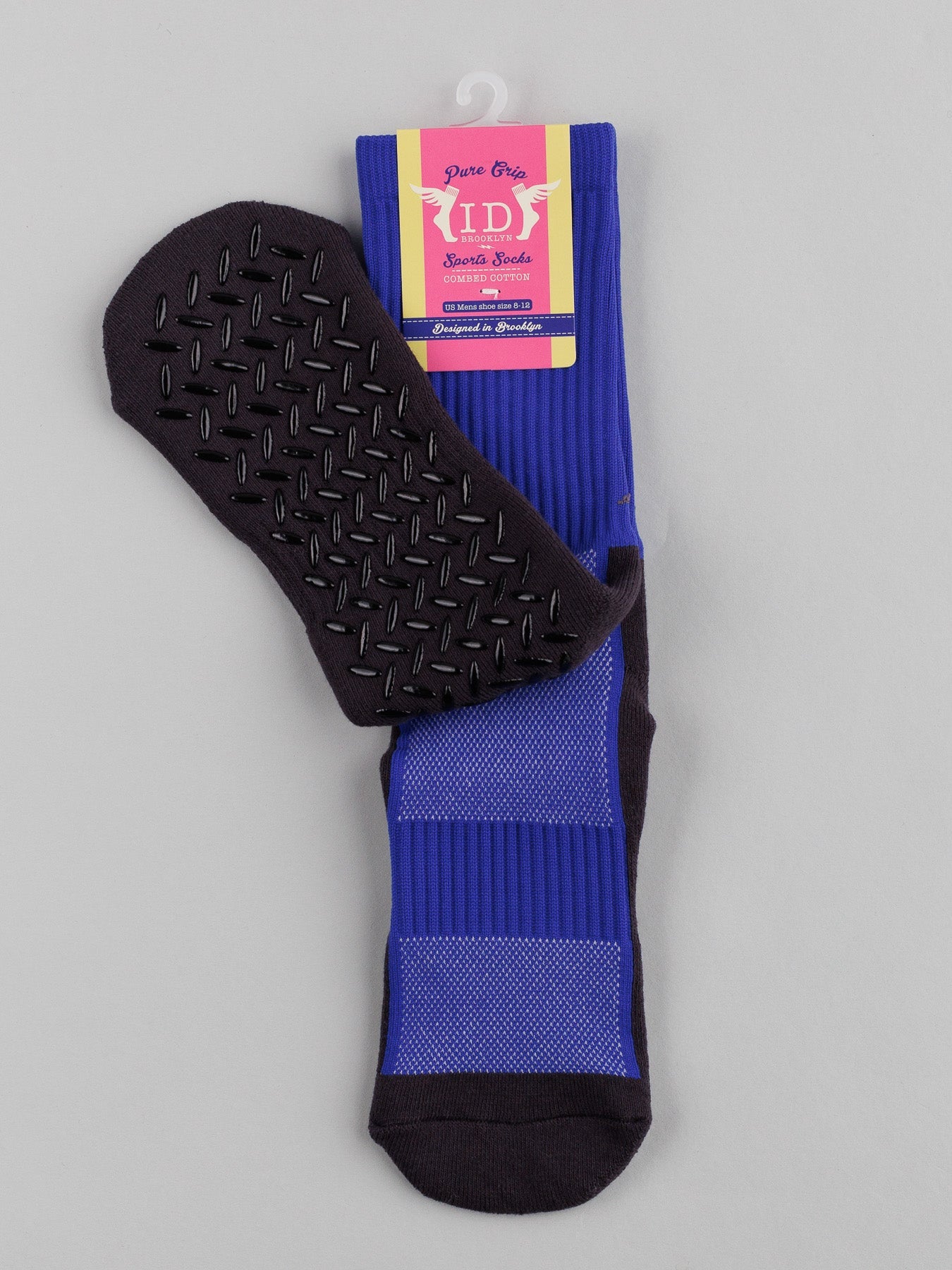 Purple childrens Grip Sports Socks by ID Menswear, showcasing a premium grip design with dark blue anti-slip soles, are neatly folded with a colorful packaging label.