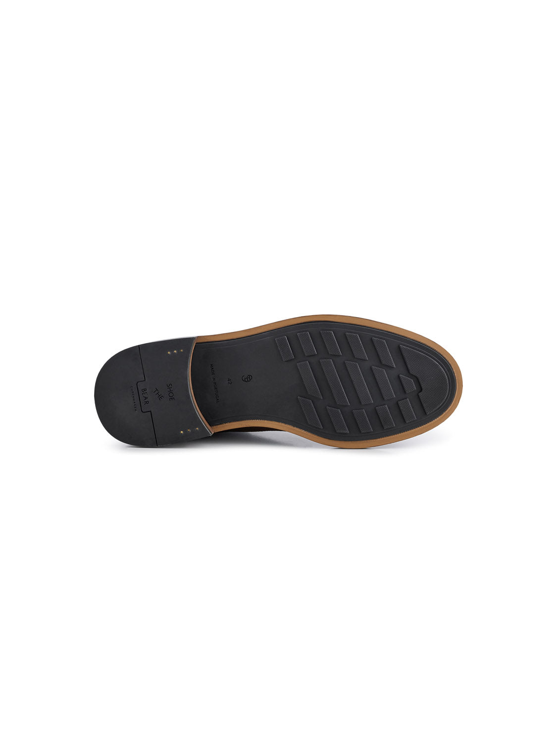 The image showcases the sole of the Ned Suede Waxed Boot by Shoe The Bear, handmade in Portugal. It has a black rubber surface with brown trim and features rectangular grooves and small circular nopps for grip.