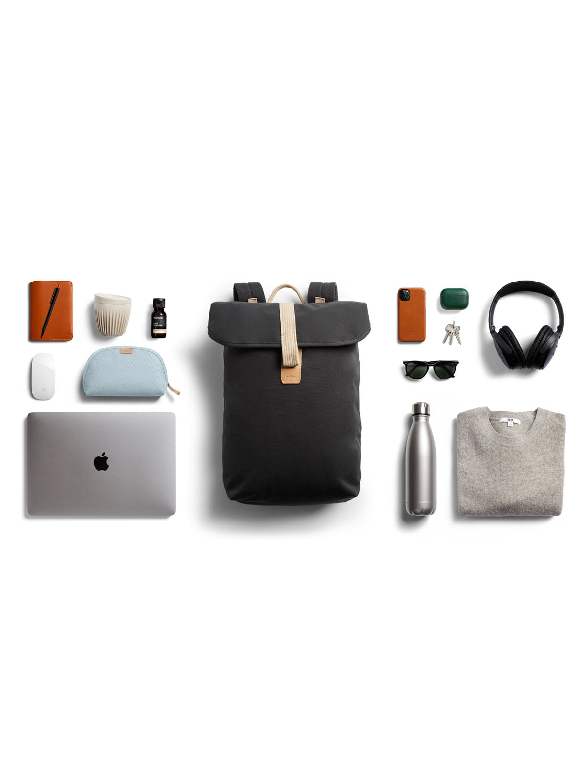 A sleek flat lay showcases the Bellroy Oslo Backpack with a silver laptop, sweater, water bottle, headphones, sunglasses, pouches, phone, wallet, keys, charger and other essentials arranged on a white background.