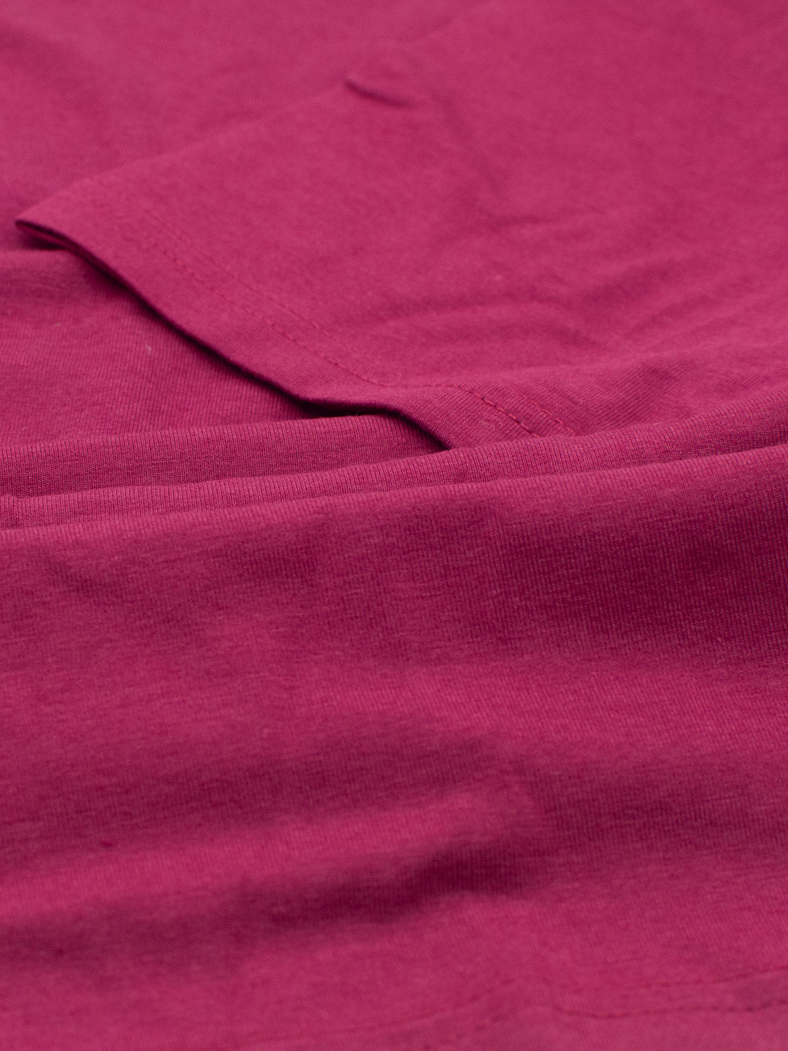 Close-up of a folded Bello Bamboo Blend Rolled Neck Tee by ID Menswear in pink, highlighting its texture and stitching details.