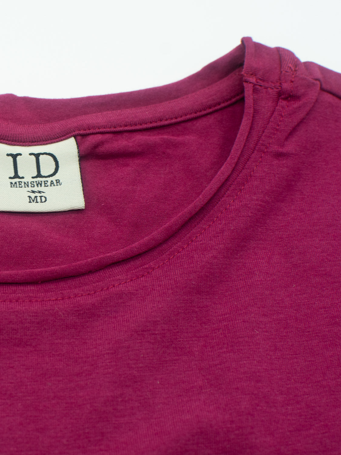 Close-up of a maroon Bello Bamboo Blend Rolled Neck Tee by ID Menswear, highlighting the neckline and label sewn into the inner back. The fabric looks soft with a slightly smooth texture, emphasizing sustainable clothing choices.