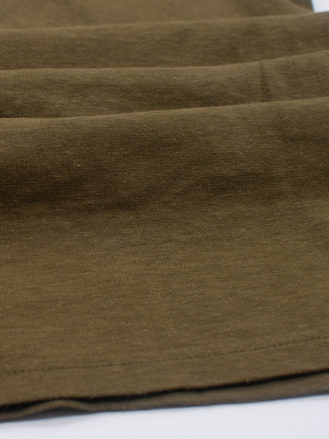 Close-up of the Dope Hemp Organic Cotton Tee by ID Menswear, showcasing the neatly layered weave and subtle color variations of its brown fabrics texture.