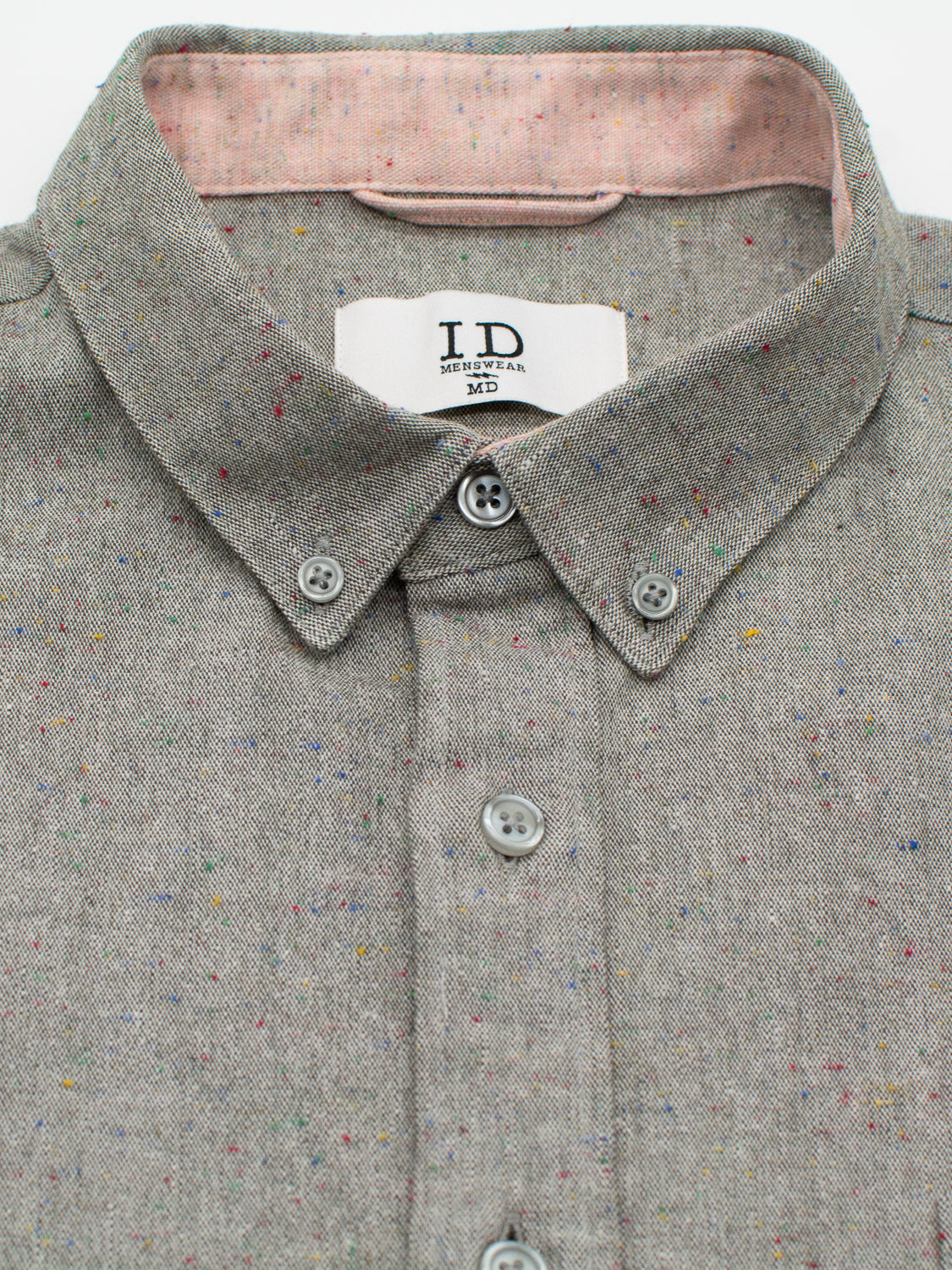 Close-up of the Allswell Speckled Button Down Shirt by ID Menswear, featuring a premium cotton-linen blend with multicolored speckles and a contrasting pink inner collar. The label reads I.D. 3rd Ave., Kithen MD.