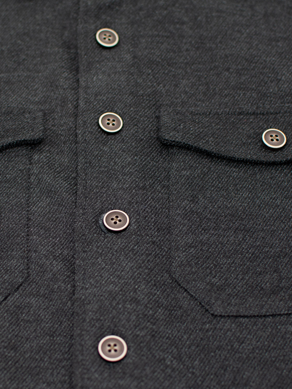 Close-up of the ID Menswear Yukon Shirt Jacket showcases its textured dark gray fabric, buttons, and two chest pockets with flaps, ideal for casual outings and transitional weather.