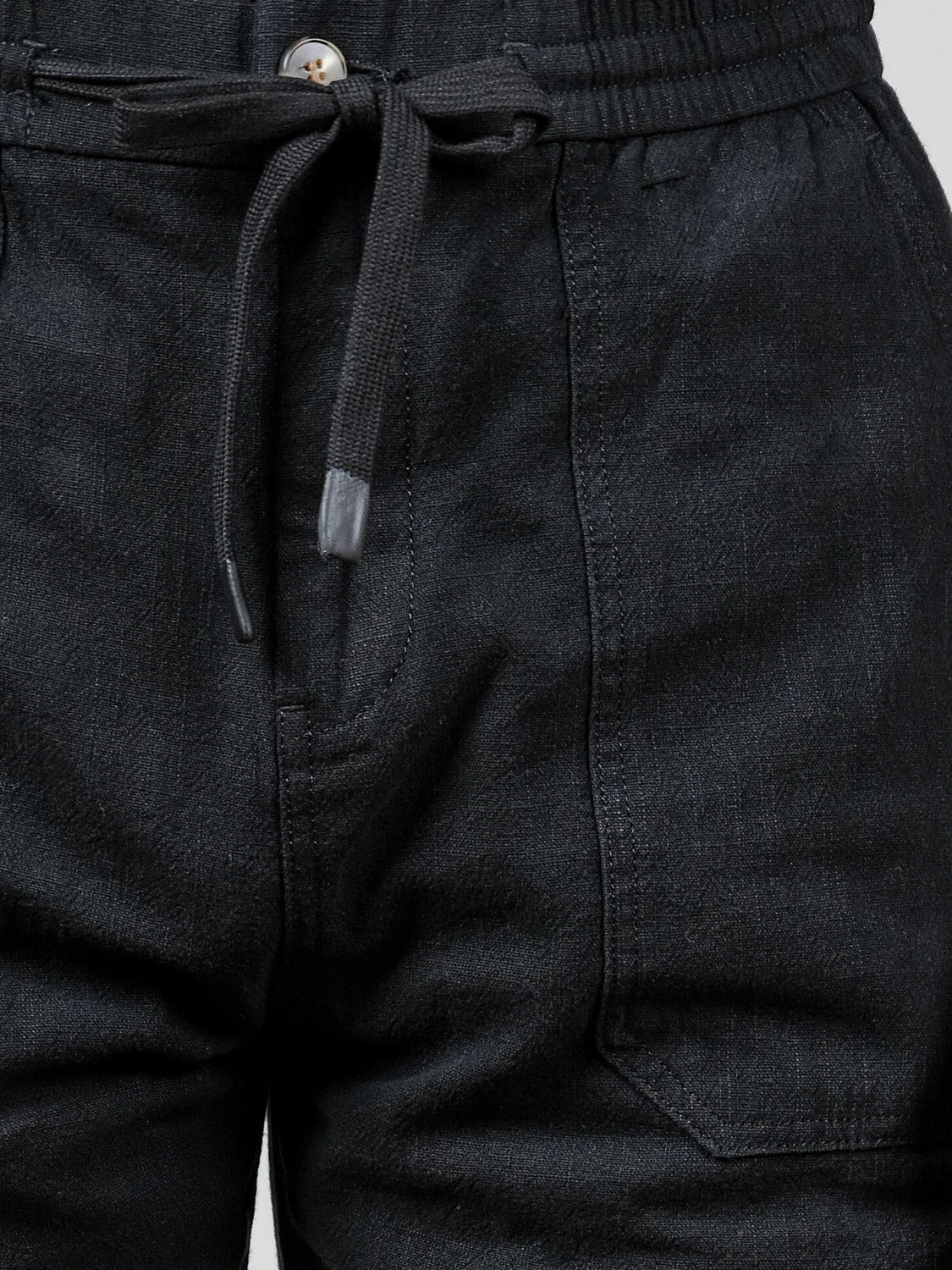 Close-up of the waist and thigh area of the Sahara Linen Cotton Pant by ID Menswear, a relaxed fit with drawstring, textured fabric, visible button, and side pockets.