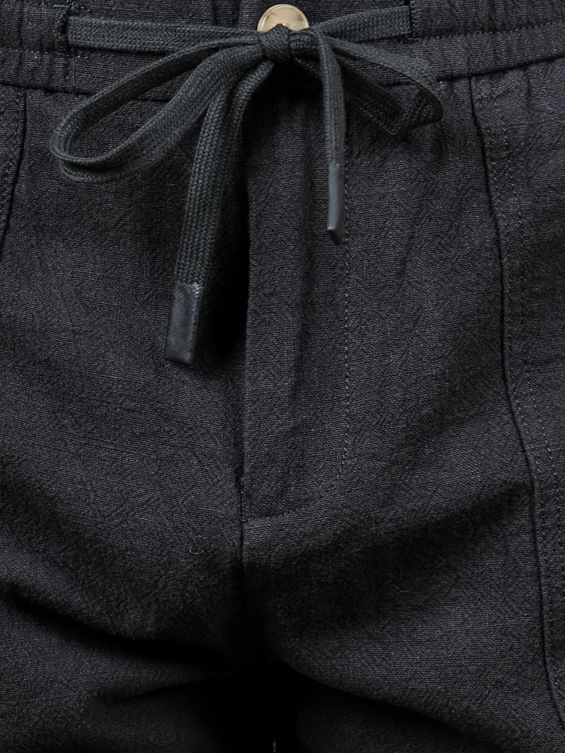 Close-up of the elastic waistband and drawstring on the Phi Phi Linen Blend Drawstring Short by ID Menswear, featuring textured linen-blend fabric and a tied black string with metal tips.