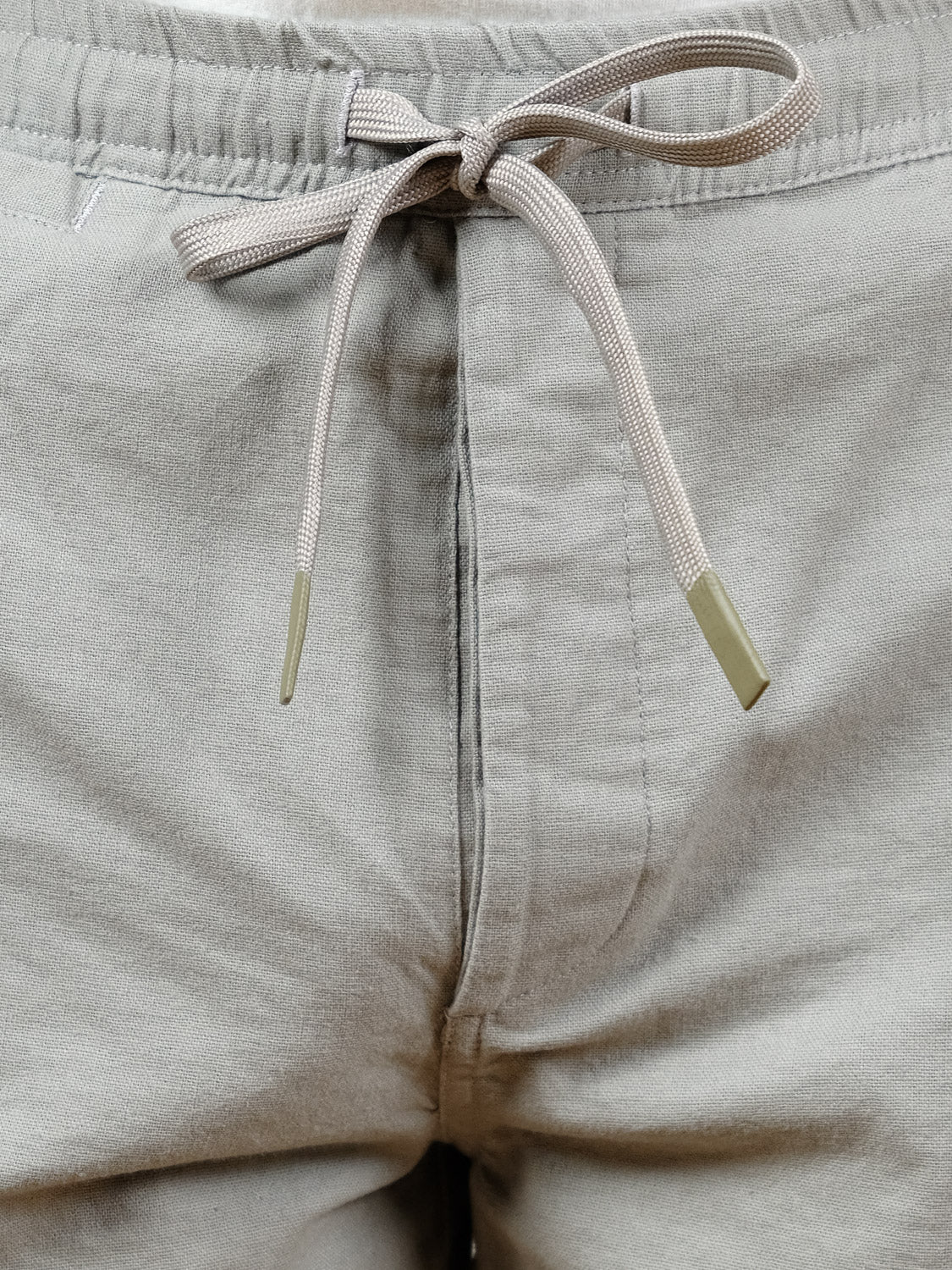 Close-up of the Kotao Linen Blend Drawstring Short by ID Menswear, featuring a light beige waistband tied in a neat bow. Made from a soft, lightweight fabric, these summer shorts offer all-day comfort.