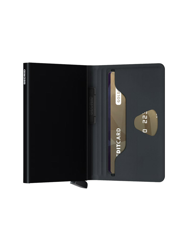 The Secrid Bandwallet TPU by Secrid, shown open in black, reveals a gold credit card in its slot. Featuring an innovative, sleek minimalist design with a visible button closure at the bottom.