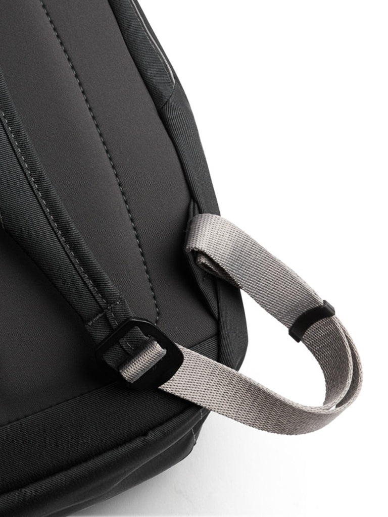 Close-up of the Bellroy Melbourne Backpack 18L, showcasing its grey carrying handle and part of a shoulder strap against a white background.