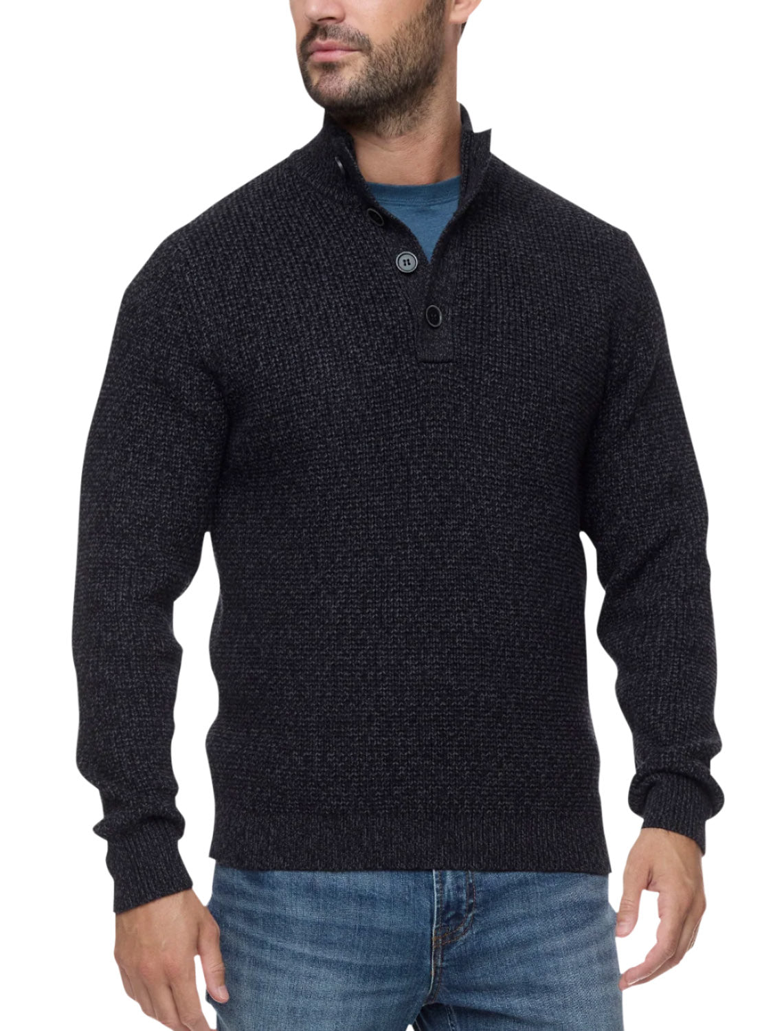A man wearing the Flag and Anthem Denver Cooling Mock Neck Sweater, a dark textured, moisture-wicking athletic fit with a buttoned-up collar, layered over a blue shirt and blue jeans, stands with his hands relaxed at his sides.