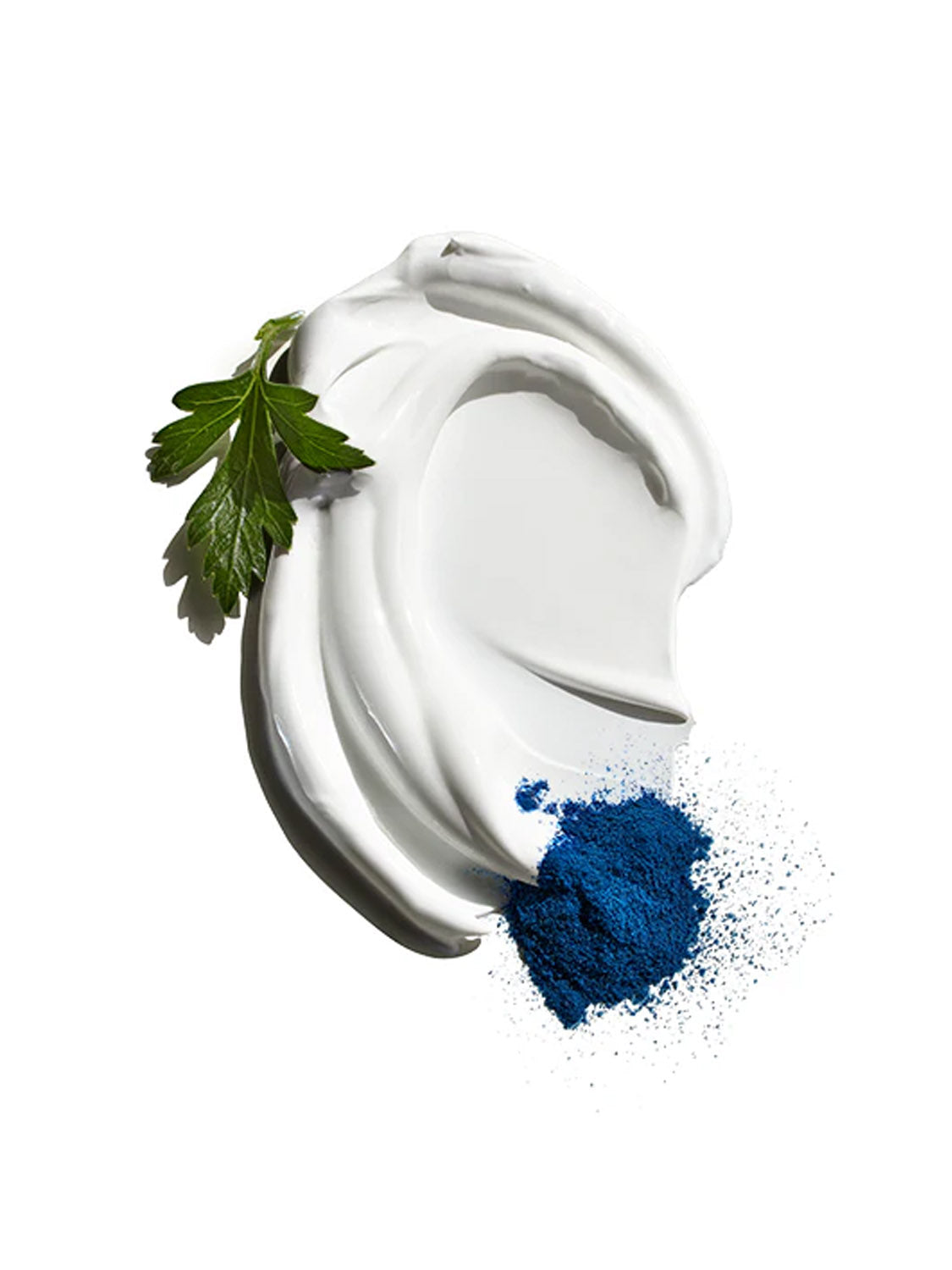 A swirl of Jack Black Double Duty Face Moisturizer SPF 20 with broad-spectrum protection is topped with a green parsley leaf, set next to a small pile of vibrant blue powder on a white background.