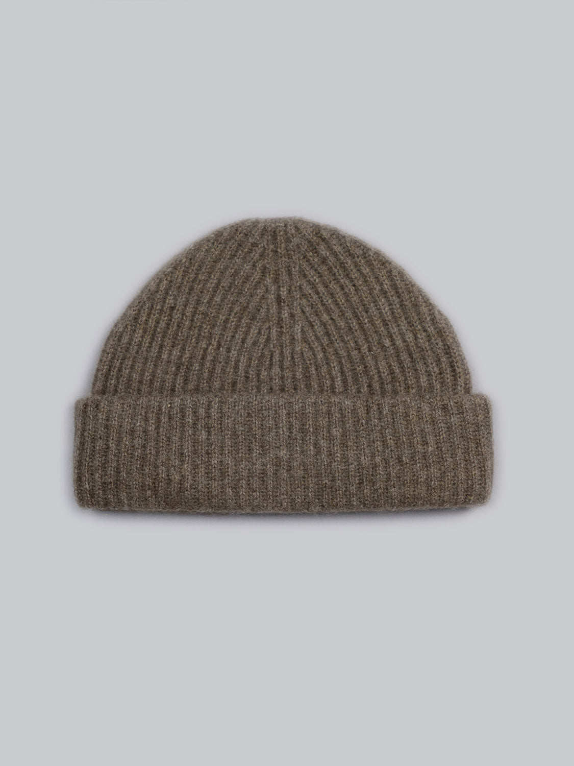 The Everest Cashmere Beanie by ID Menswear is a brown, ribbed knit hat with a folded brim, shown on a plain light gray background—a lightweight essential for versatile style.