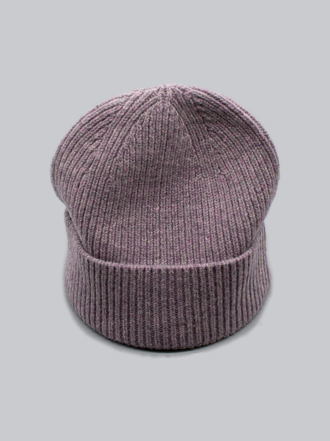 The Fuji Merino Wool Beanie by ID Menswear is showcased on a light gray backdrop. Its a purple, ribbed knit accessory, displayed upright with its cuff folded up, emphasizing the vertical texture.
