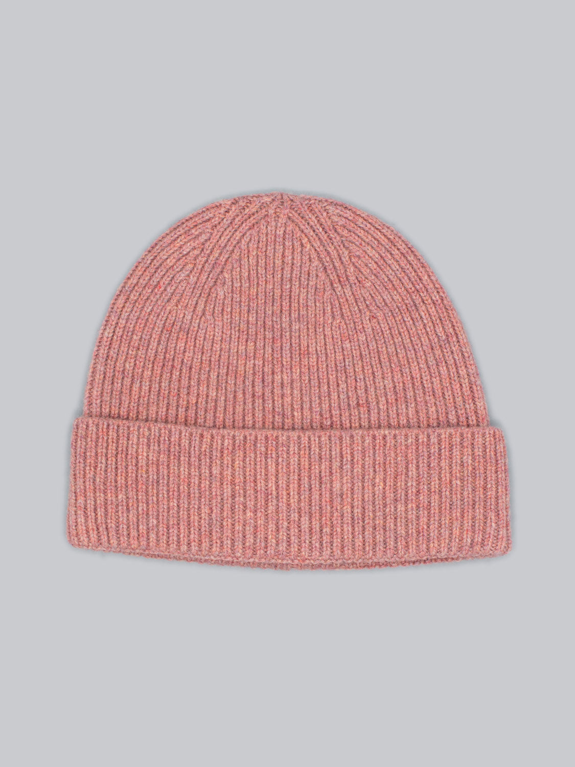 The Fuji Merino Wool Beanie by ID Menswear is the perfect winter companion, featuring a pink knit design with ribbed texture and a folded brim, all set against a plain light gray background.