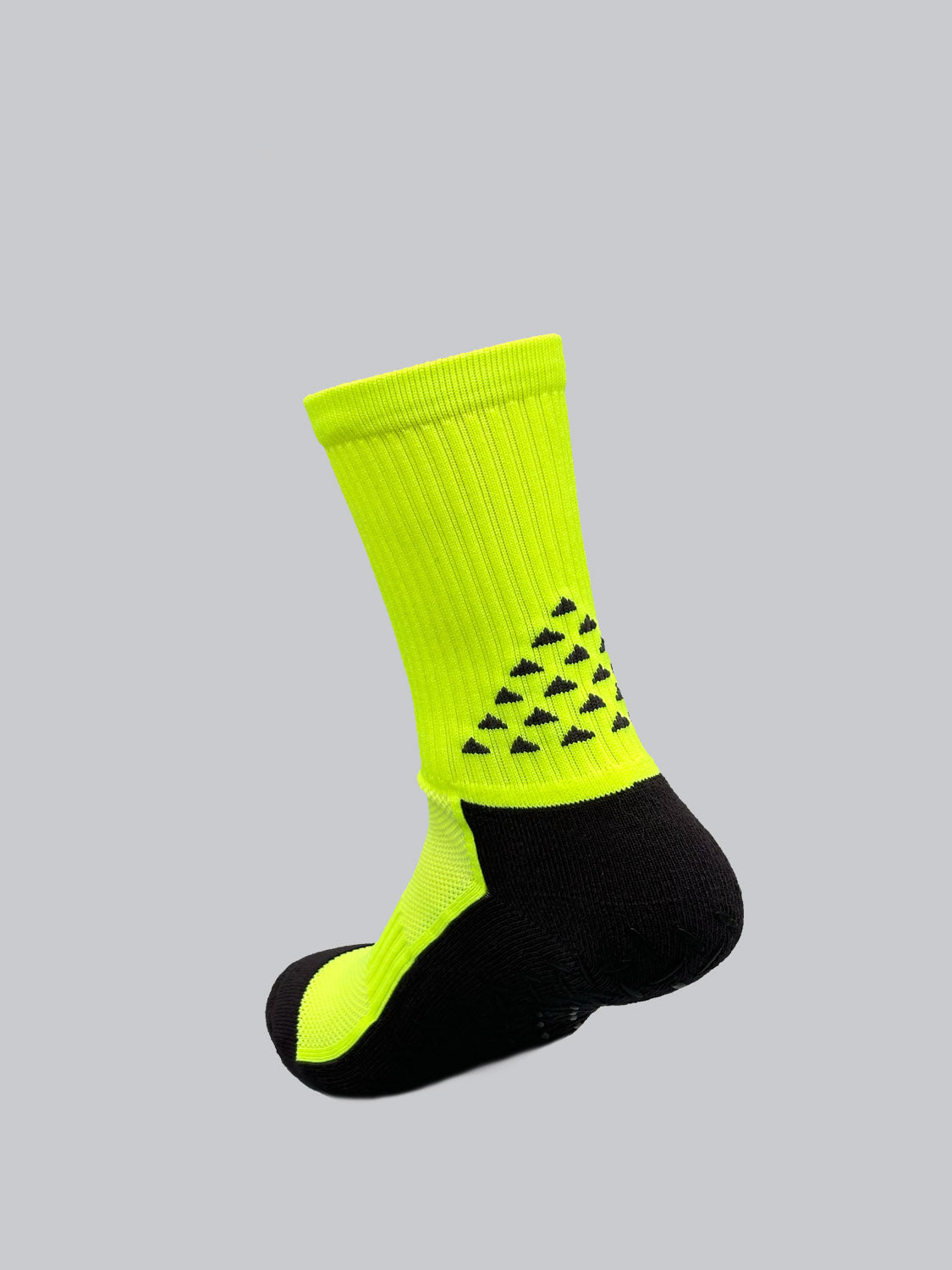 The Grip Sports Socks by ID Menswear boast a vibrant neon yellow and black design with ribbed texture, triangular dot patterns, and anti-slip soles for performance and comfort, all on a light gray backdrop.