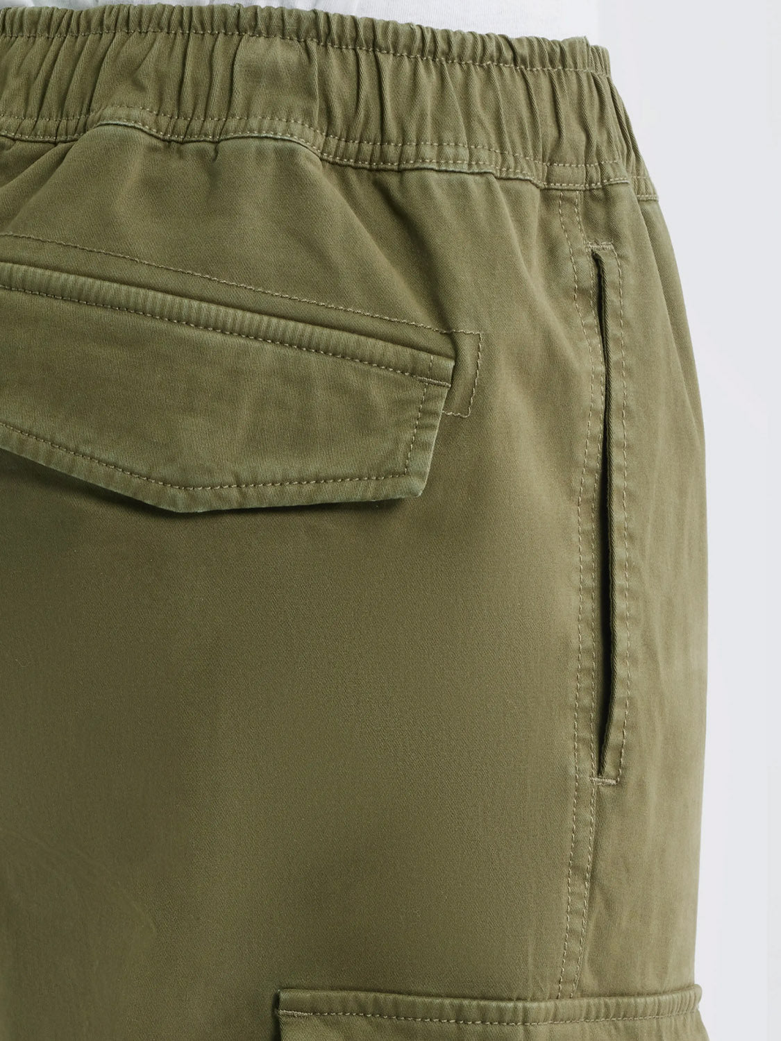 Close-up of Rails Jaiden Cargo Pants in olive green, featuring an elastic waistband, a buttoned flap pocket, and a vertical side pocket, inspired by utility wear—all shown on a plain background.