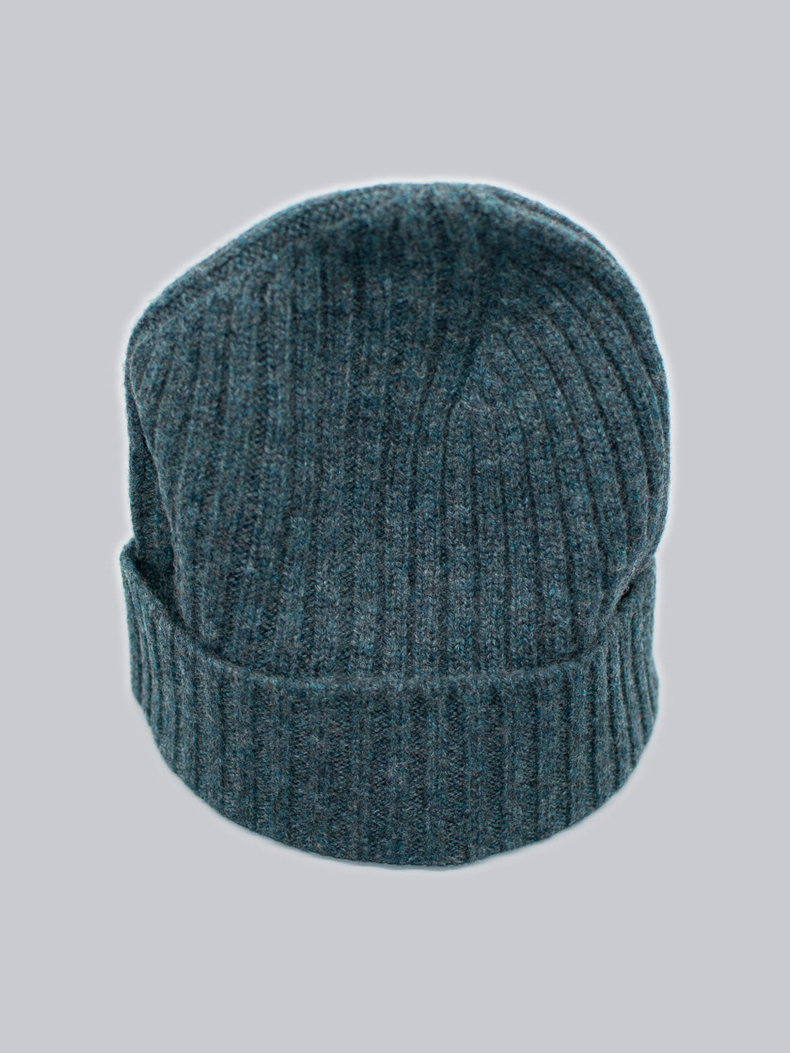 The Kailash Merino Wool Beanie by ID Menswear is a gray ribbed knit hat with a folded brim, ideal for warmth and softness during outdoor adventures, shown on a light gray background.