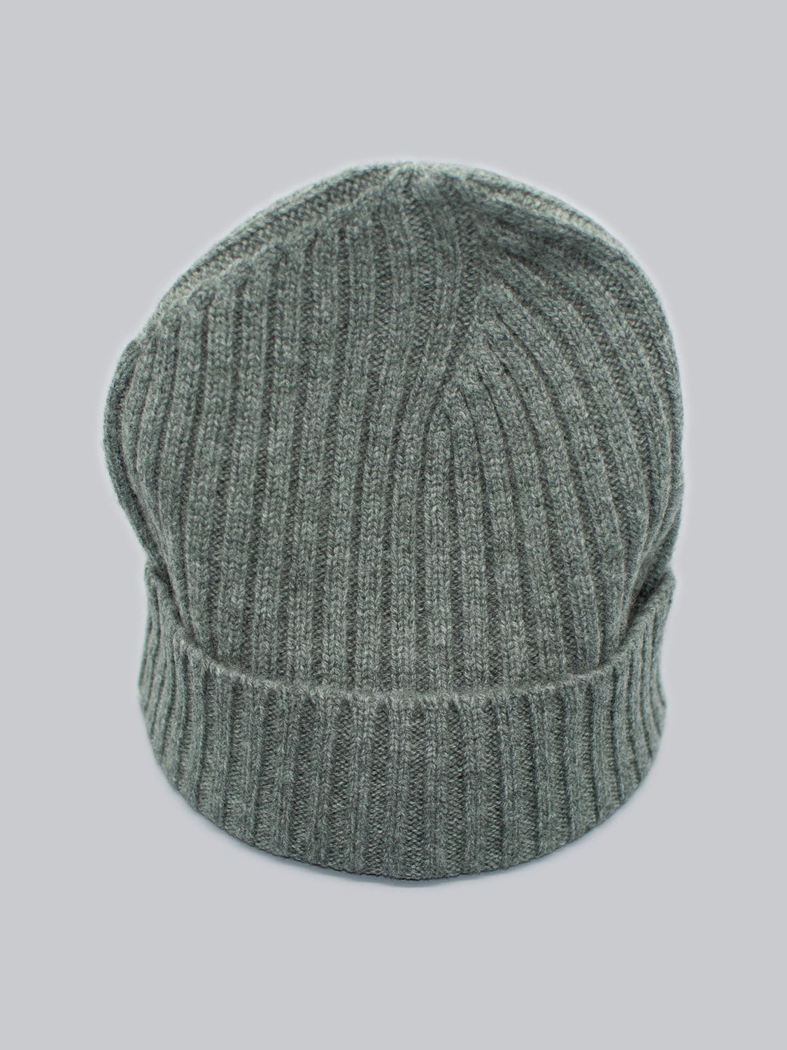 The Kailash Merino Wool Beanie by ID Menswear is displayed against a light gray background. Its gray ribbed Merino wool is warm and soft, with a slightly fuzzy texture. The gathered top gives it a slouched appearance, ideal for outdoor adventures.