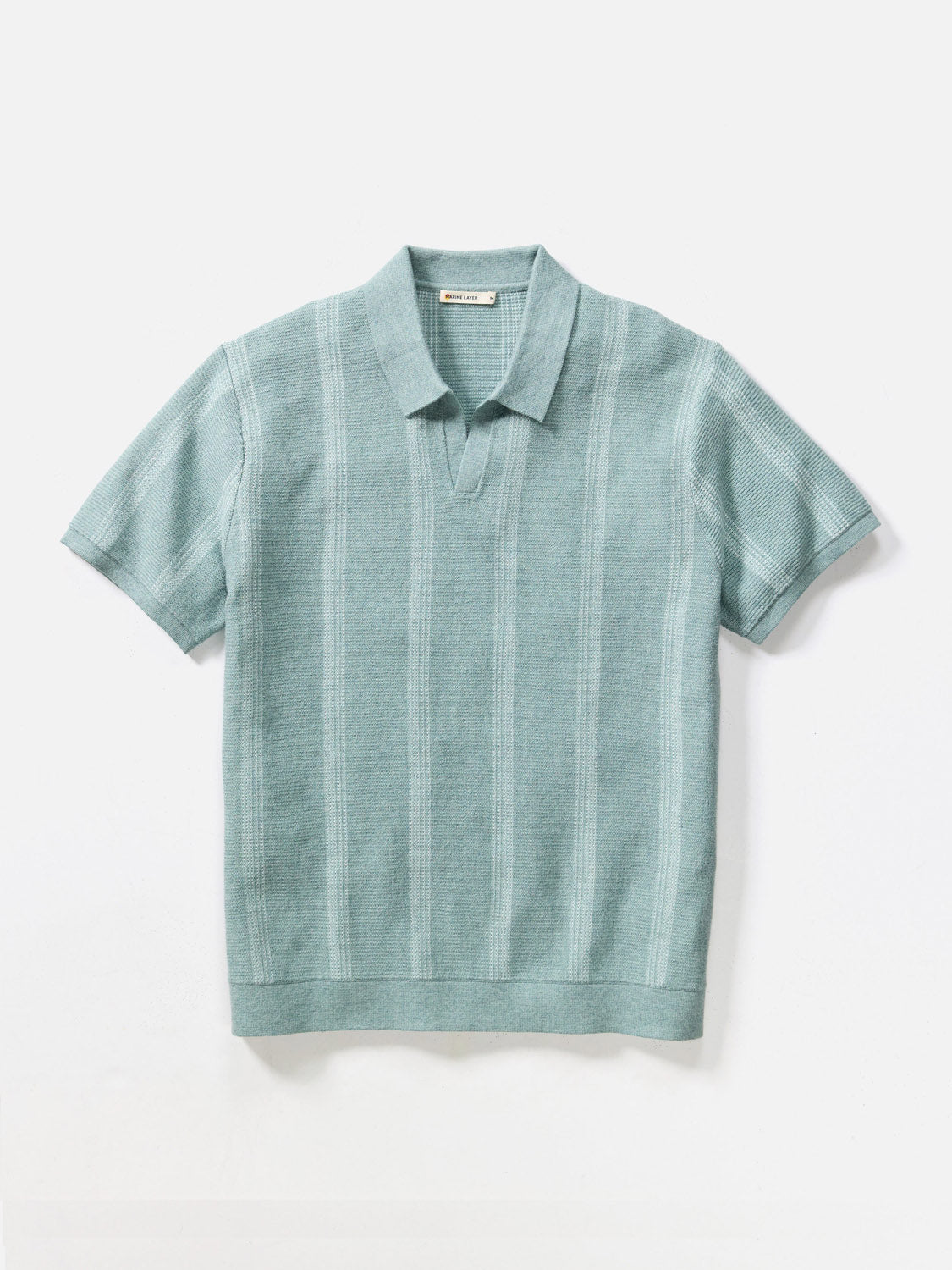 The Marine Layer Liam Sweater Short Sleeve Polo features a light teal hue with ribbed texture, vertical stripe details, short sleeves, and a collar. Shown on a plain white background.