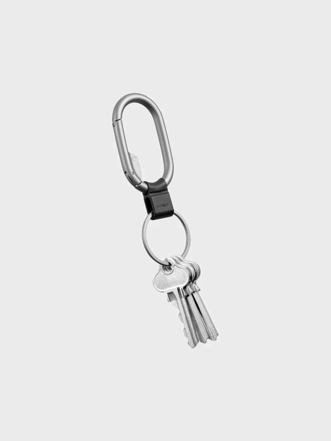 The Orbitkeys Clip Mini Keyring is a minimalist carabiner keychain featuring a metal keyring with four silver keys, shown against a plain light gray background.