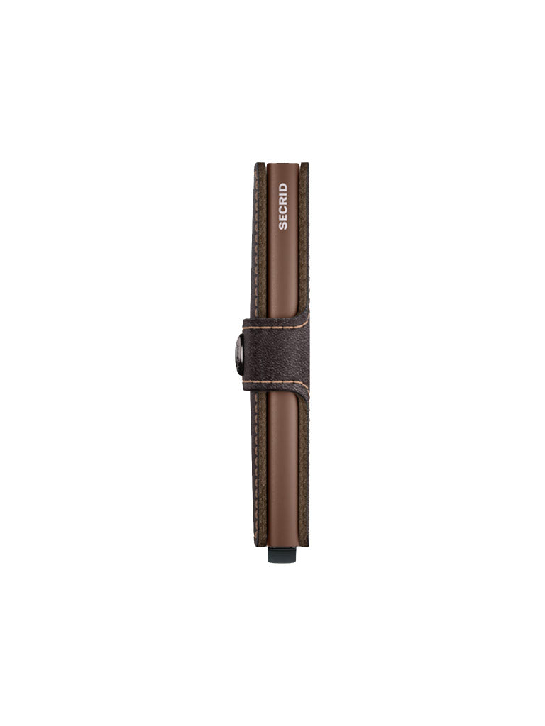 The Secrid Miniwallet Original is a slim brown wallet made from European leather with visible stitching, SECRID branding on the edge, a central metal button clasp, and built-in RFID protection.