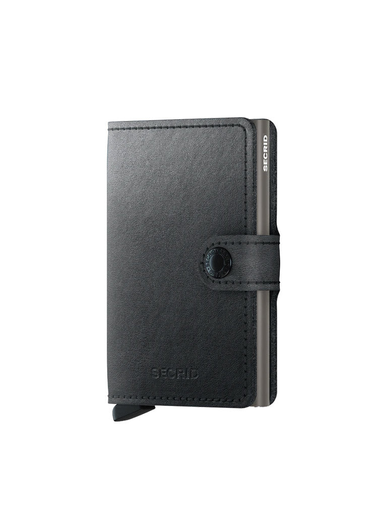 A black Secrid Miniwallet Mirum with button snap closure, RFID protection, minimalist design, and exposed metal card holder is displayed standing upright on a white background.