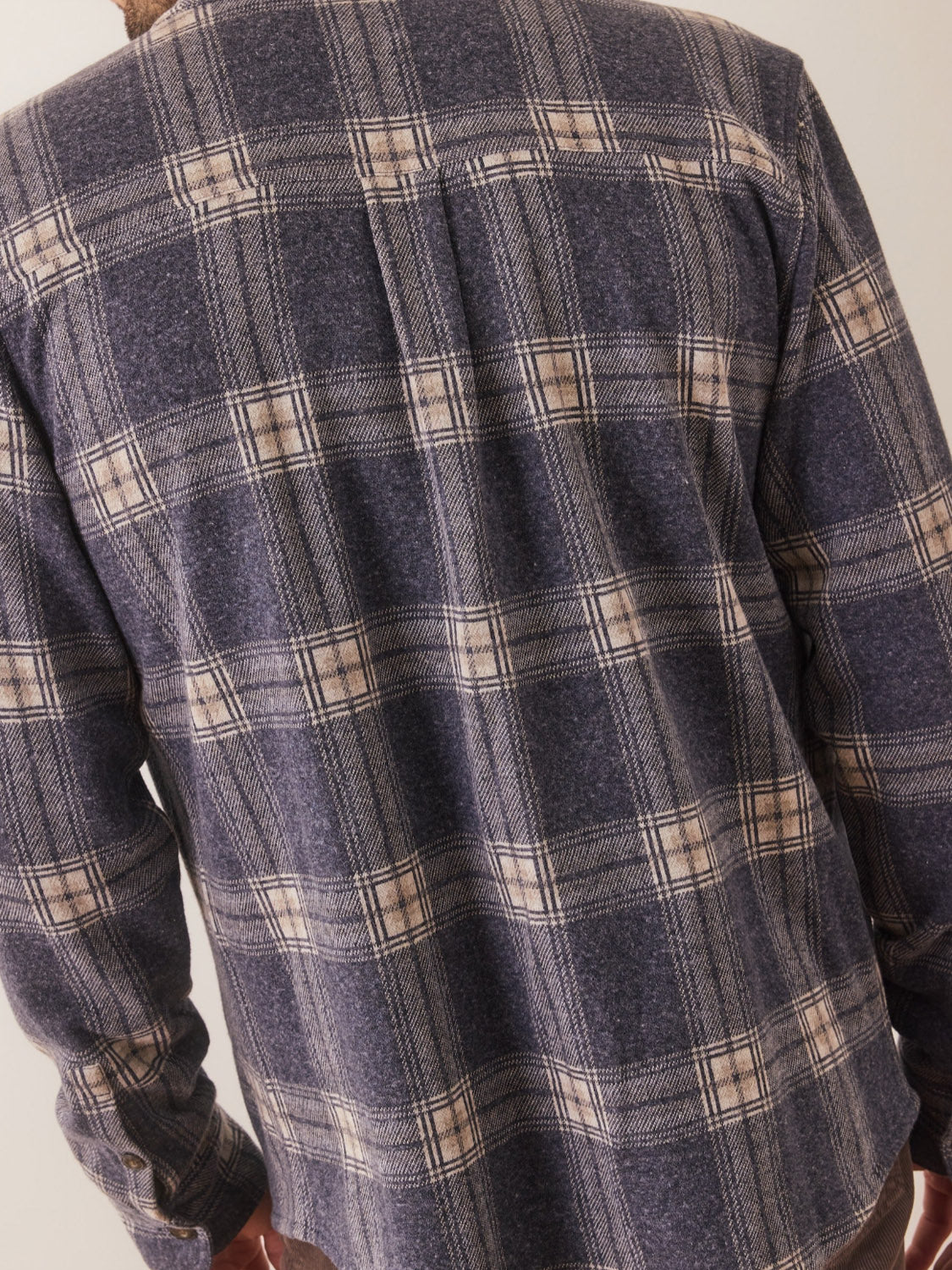 A person shown from the back wearing the Marine Layer Pacific Stretch Twill Shirt, featuring a blue and beige checkered pattern and long sleeves.
