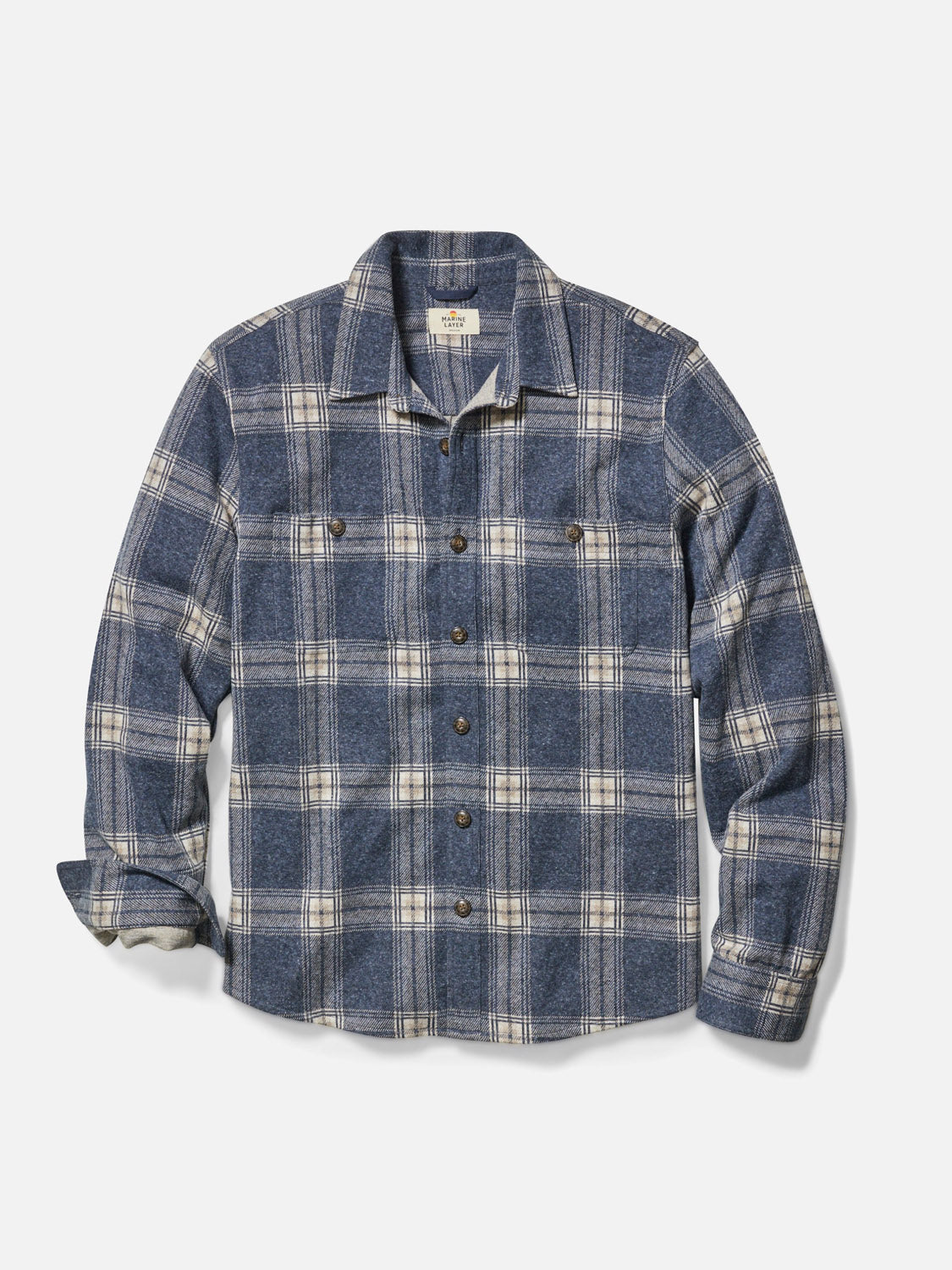 The Marine Layer Pacific Stretch Twill Shirt features a blue and gray plaid pattern, long sleeves, button-down front, two chest pockets, and a spread collar, shown flat on a white background.