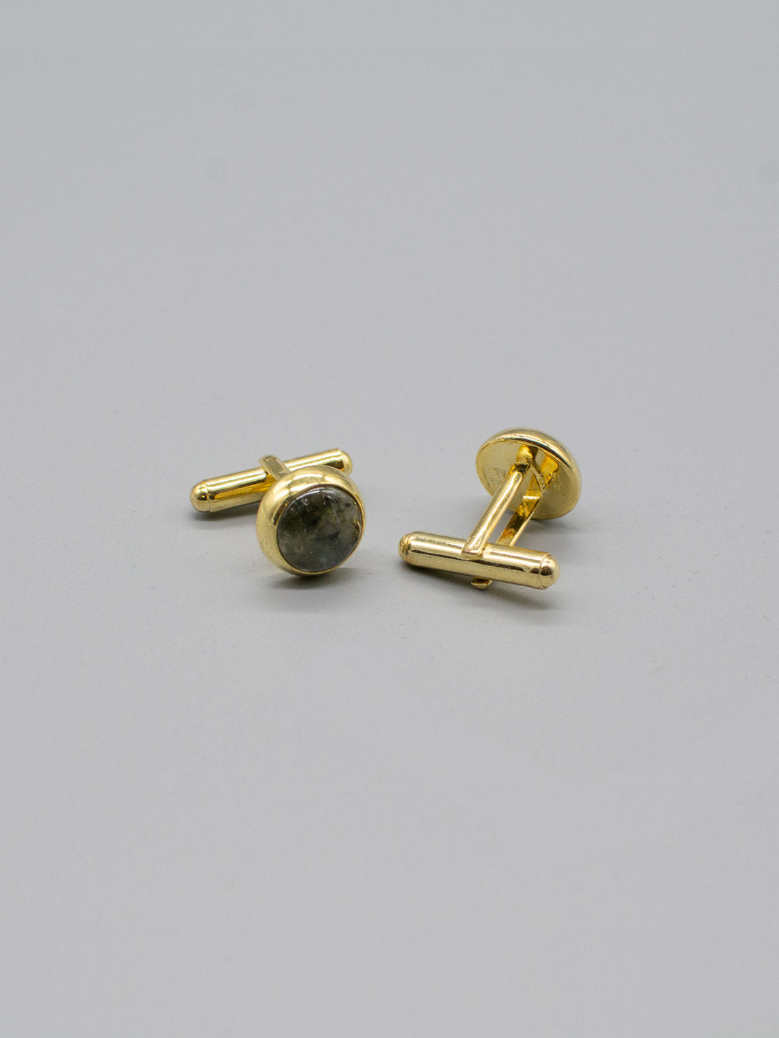 ID Menswears Gold Plated Silver Gemstone Cufflinks feature a sleek bar design with gemstone inlay, shown on a gray surface. One cufflink is upright, the other flat, both with classic bullet back fastenings for easy use.