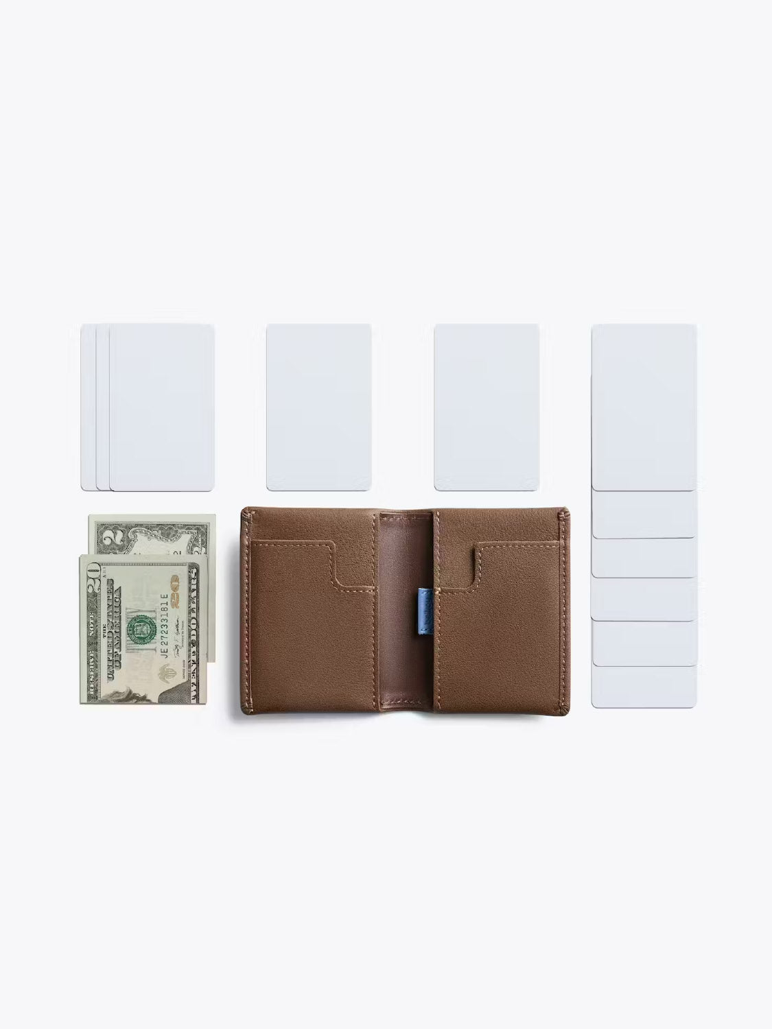 The Bellroy Slim Sleeve Wallet, shown open and empty on a white background, is surrounded by several blank cards and two neatly folded US dollar bills.