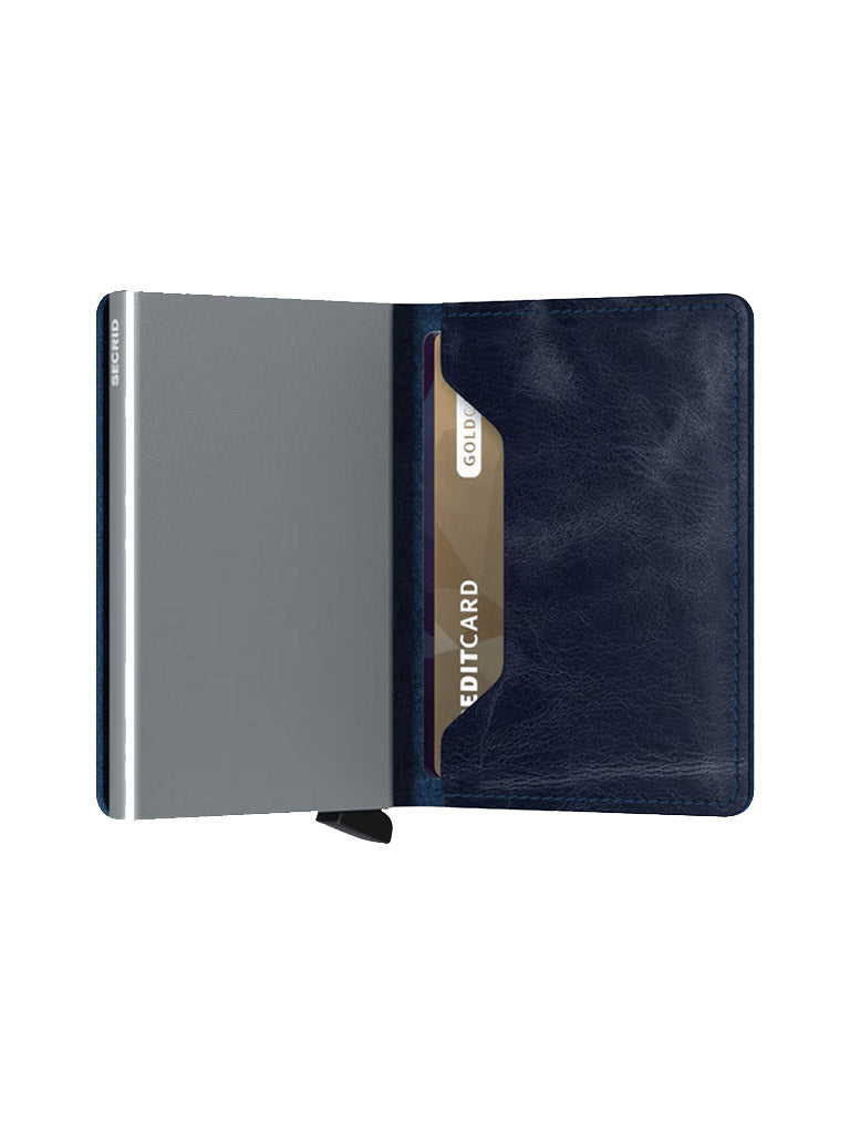 The Secrid Slimwallet Vintage Leather by Secrid is shown open in dark blue, with a single credit card partly visible on the right and a plain metallic section on the left for added RFID/NFC security.