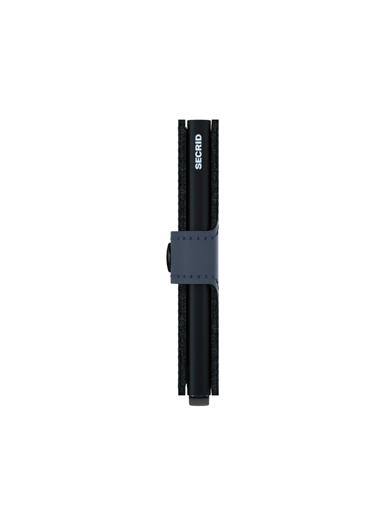A Secrid Miniwallet Matte Finish Leather is shown closed and upright, secured by a navy blue strap and button, against a white background—a compact wallet with RFID protection.