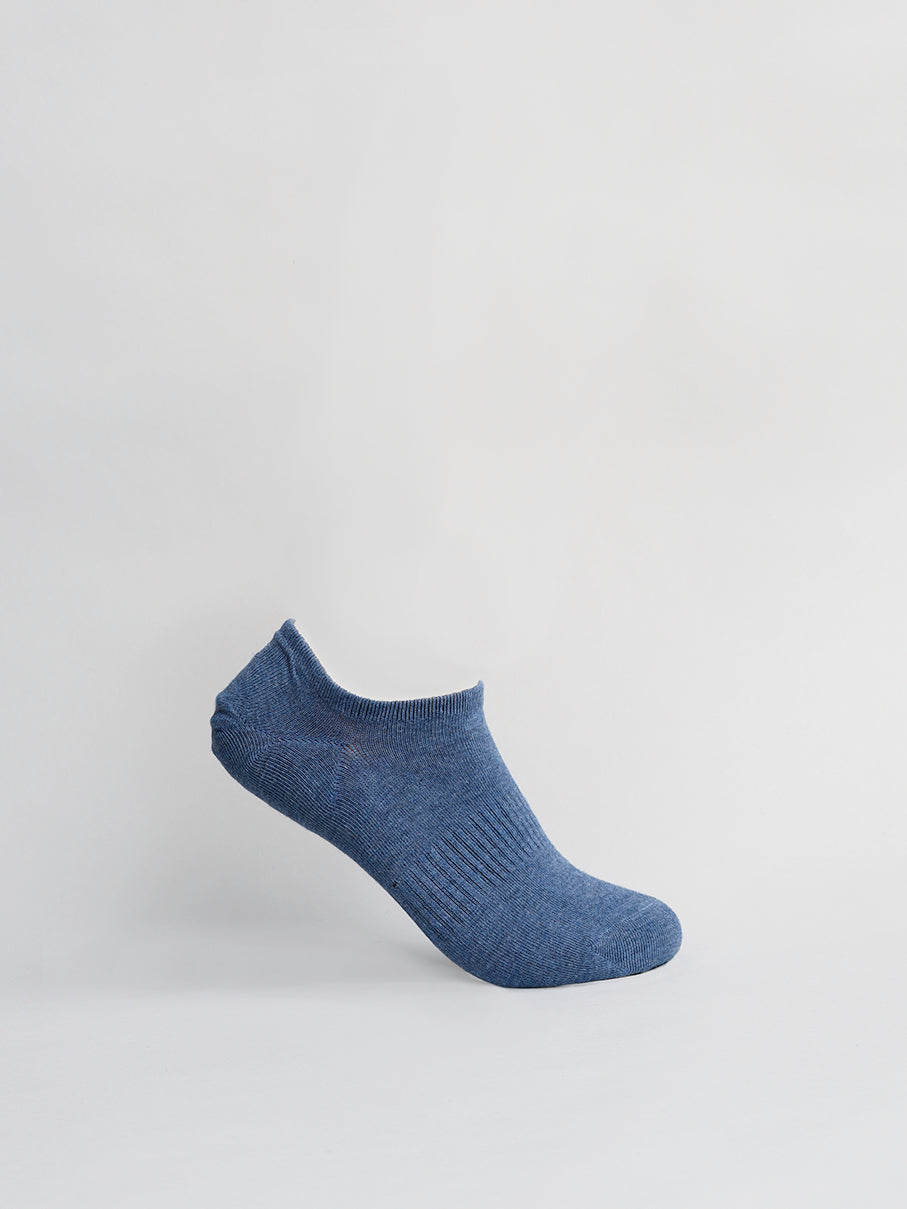 A single blue No Show Ribbed Sock by ID Menswear is displayed against a plain white background. It stands upright, showcasing its side profile with visible ribbed detailing on its breathable fabric.