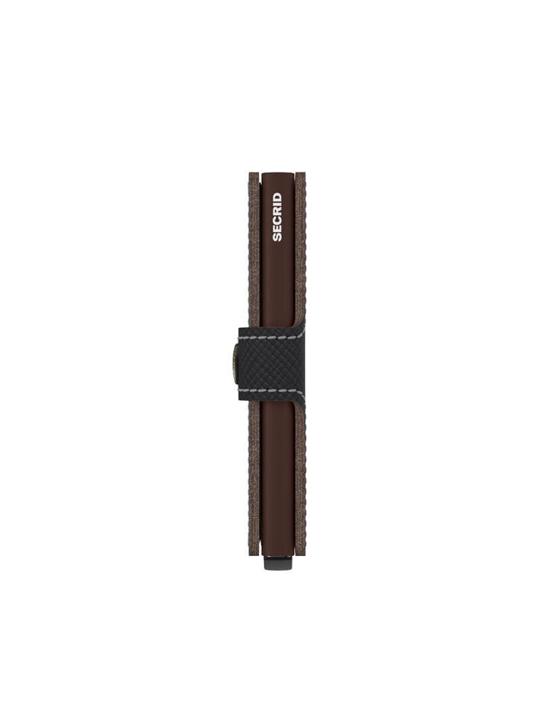 The Secrid Miniwallet Saffiano Leather in brown features RFID protection, a black textured strap, white stitching, and SECRID in white lettering on the edge, as seen from the side.