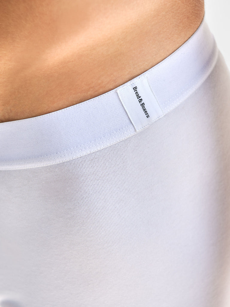 Close-up of a person wearing Bread & Boxers - 3 Pack Boxer Brief, featuring an elastic waistband and a discreet label. The smooth fabric is slightly elastic, made from organic cotton for comfort.
