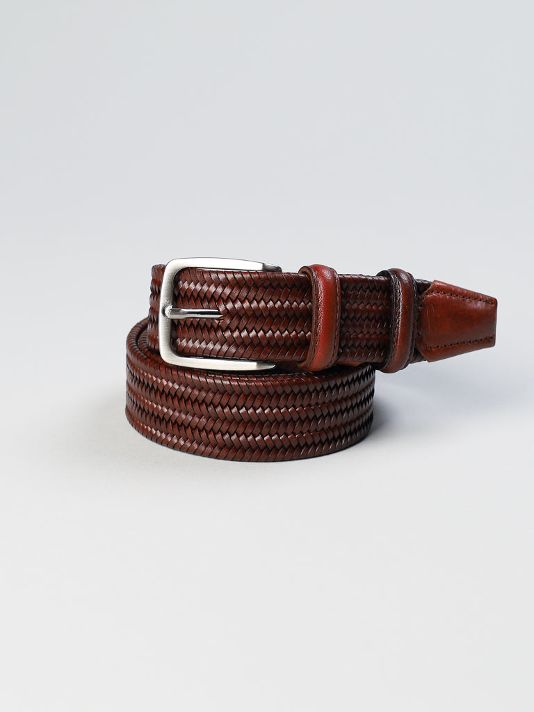 The 4553 Made in Italy Braided Leather Belt by ID Menswear features a coiled brown woven texture with a silver buckle, crafted from genuine Italian leather.