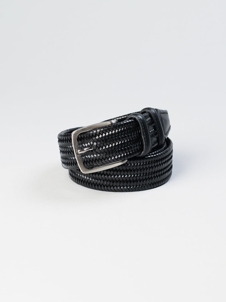 The 4553 Made in Italy Braided Leather Belt by ID Menswear is crafted from genuine black woven leather and features a sleek silver buckle, coiled neatly on a plain white background.