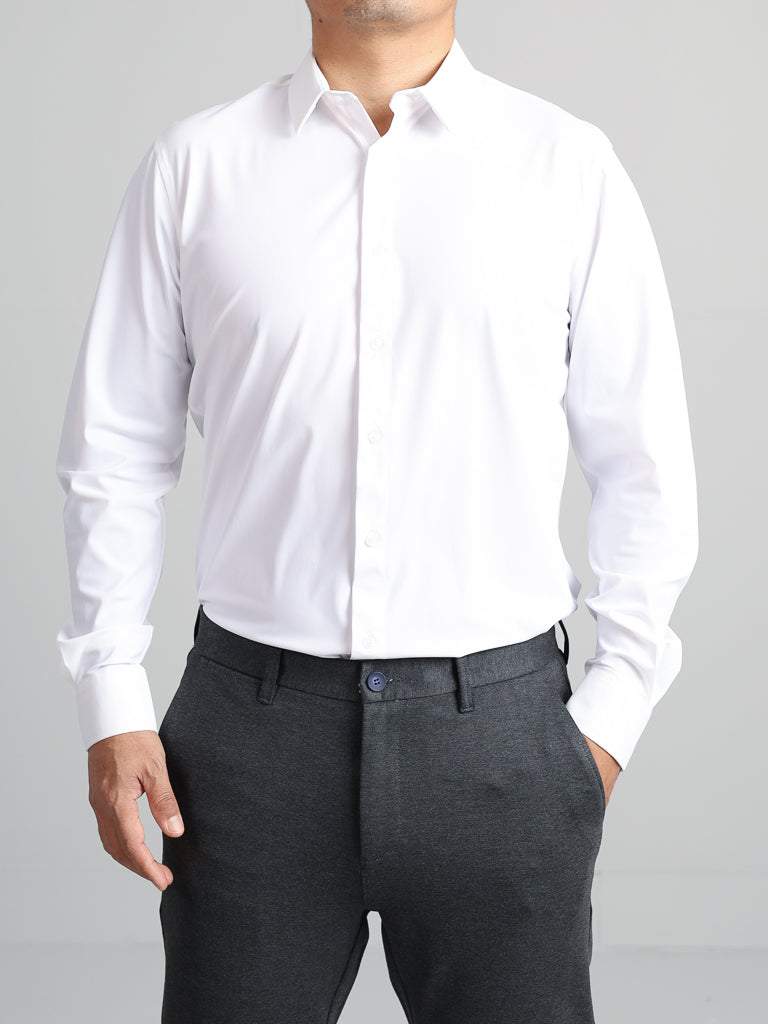 A person wears a slim-fit Axel 4-Way Stretch Dress Shirt by ID Menswear and dark gray trousers against a neutral background. The sleek, buttoned-up shirt offers style and comfort; one hand is in a pocket, the other hangs by their side. The subjects head is outside the frame.