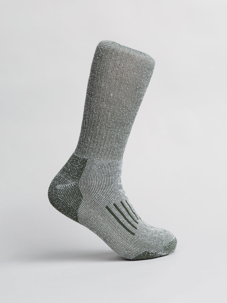 Showcase the ID Menswear Merino Wool Blend Socks on a plain light background. With a ribbed ankle texture and soft sole, these socks stand upright with the toes pointing down, providing comfort in cold weather.