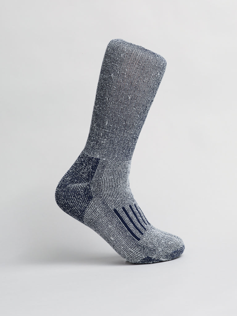 A gray Merino Wool Blend Sock by ID Menswear stands upright on a white backdrop, featuring a ribbed texture for elegance and slightly darker heel and toe sections. Its soft, speckled wool blend ensures breathability and comfort in cold weather.