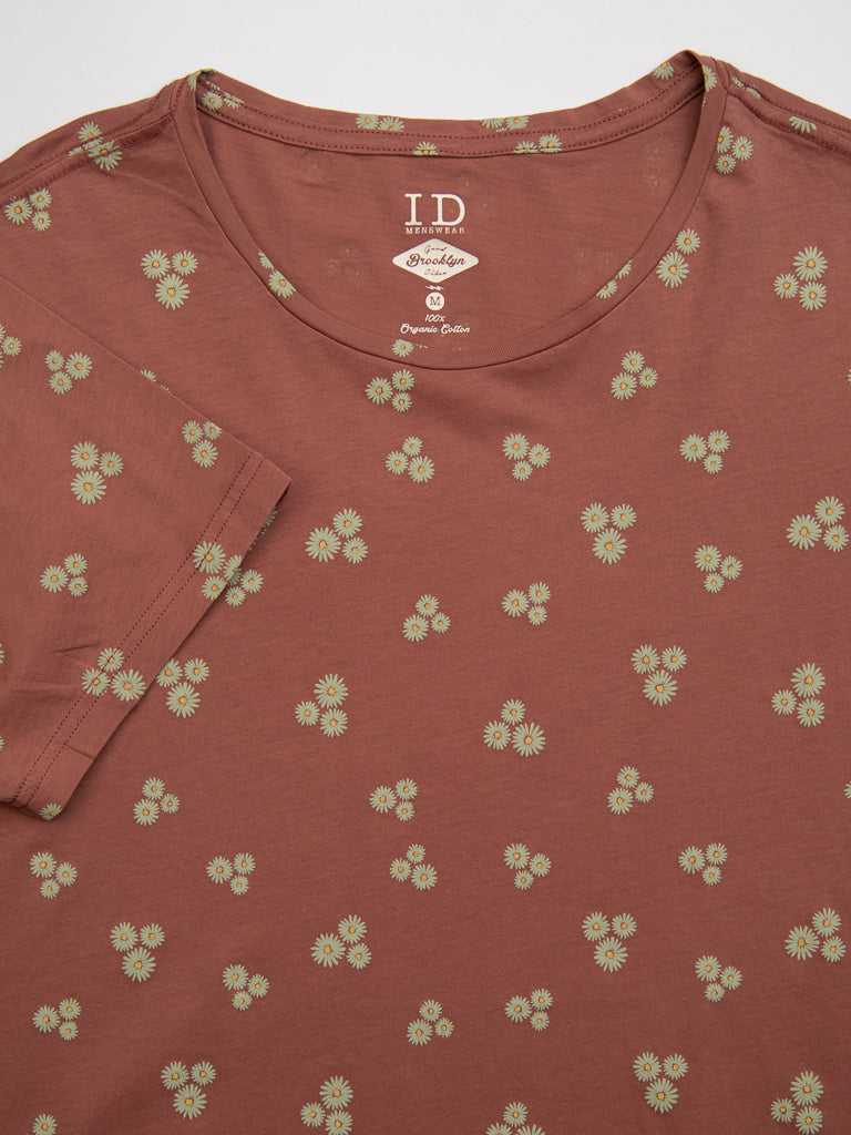 A brown Heritage Printed Organic Cotton Tee from ID Menswear with a round neckline, features a hand screen-printed pattern of small green and yellow flowers on organic cotton. Inside label: I.D. Byrdie Organic Cotton.