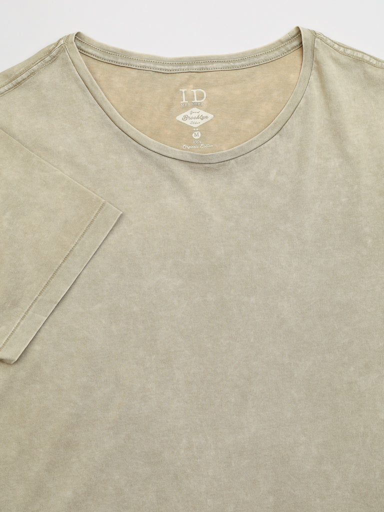 The Legacy Organic Cotton Tee by ID Menswear features a faded olive green color, round neckline, and short sleeves. Made from organic cotton, it offers a classic fit with a washed vintage look for a slightly worn appearance. Laid flat on a white background.