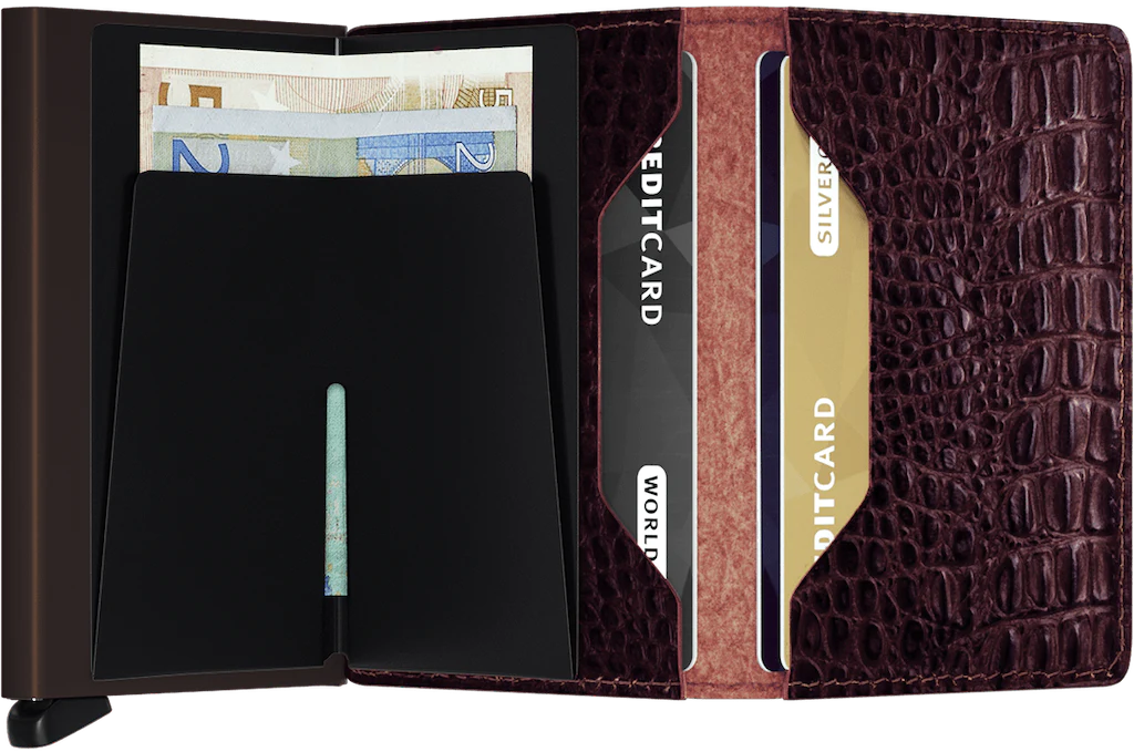 The Secrid Slimwallet Nile is an open brown leather billfold with a crocodile texture, holding euro banknotes and three credit cards in separate slots. Stylish and practical, this slim wallet blends elegance with functionality.