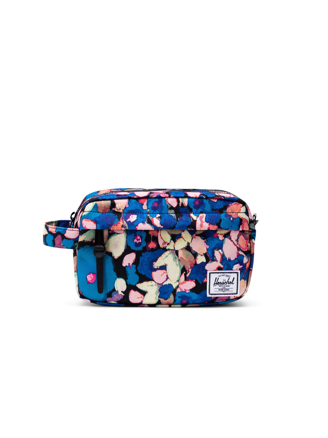 The Herschel Chapter Travel Kit is a rectangular toiletry organizer with a colorful abstract floral pattern in blue, pink, and yellow, featuring a waterproof zipper, a side handle, and a white Herschel label on the front.