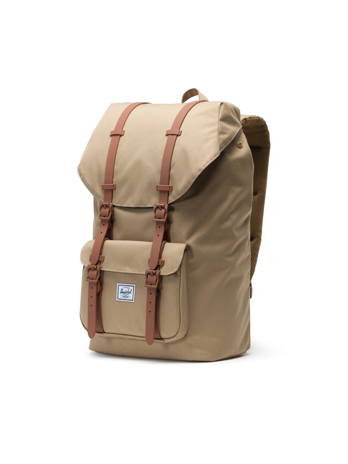 The Herschel Little America Iconic Backpack is a tan canvas mountaineering bag with brown leather straps, a front pocket, and a small rectangular logo. It has a flap closure, padded shoulder straps, and a laptop sleeve for convenience.