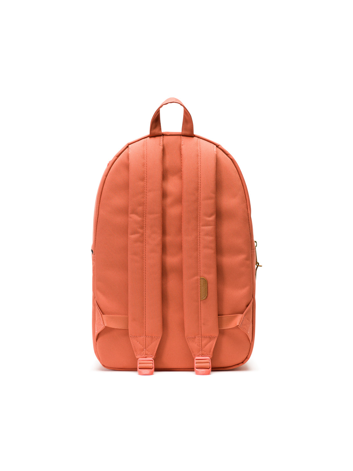 The Herschel Settlement Backpack in coral is shown from the back with padded shoulder straps, a small top handle, built-in laptop sleeve, and minimal detailing, all set against a plain white background.