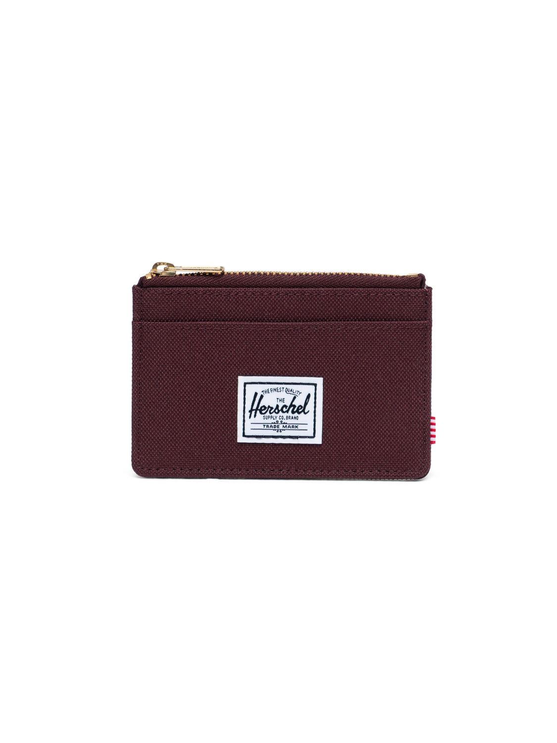 The Oscar Compact Wallet by Herschel features maroon fabric, two front card slots, a zippered top, and a white Herschel label. This slim wallet is shown against a plain white background.
