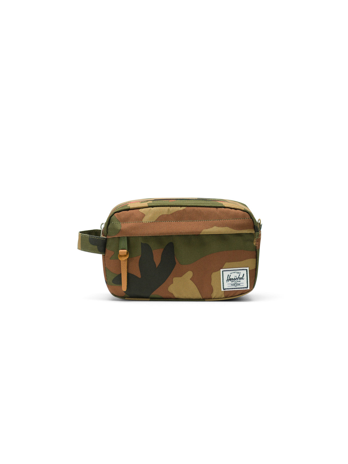 The Herschel Chapter Carry-On Travel Kit is a small rectangular bag with a camouflage print, side handle, waterproof zipper, tan pull, and a white front label, shown on a plain white background.