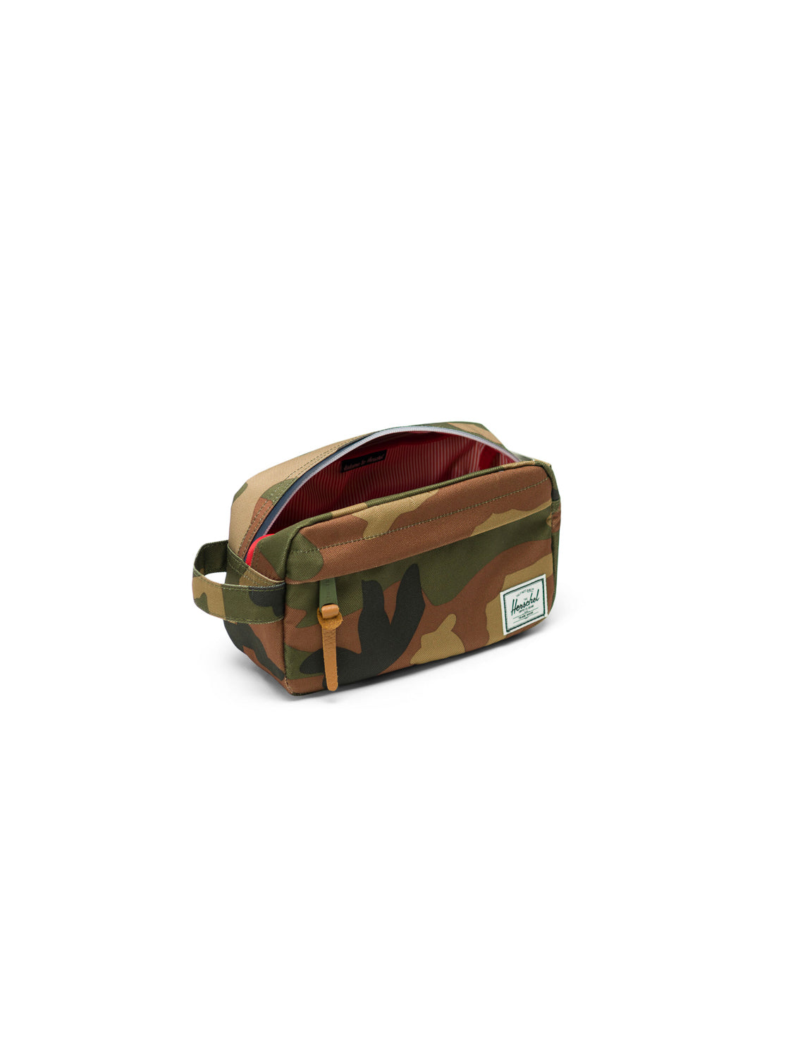 The Herschel Chapter Carry-On Travel Kit features a camouflage pattern, side handle, waterproof zipper revealing a red-striped interior, and a white rectangular Herschel label on the front—ideal for stylish travel.